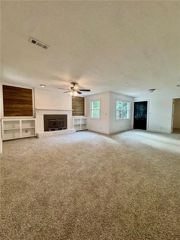 an empty room with fireplace and windows