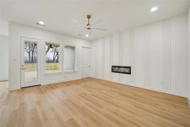 a view of an empty room with wooden floor and cabinet