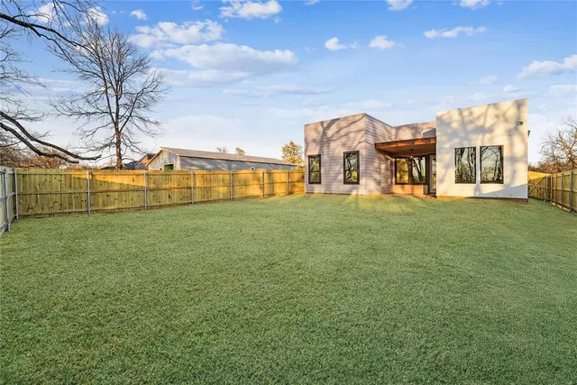 a view of a house with a big yard and large trees