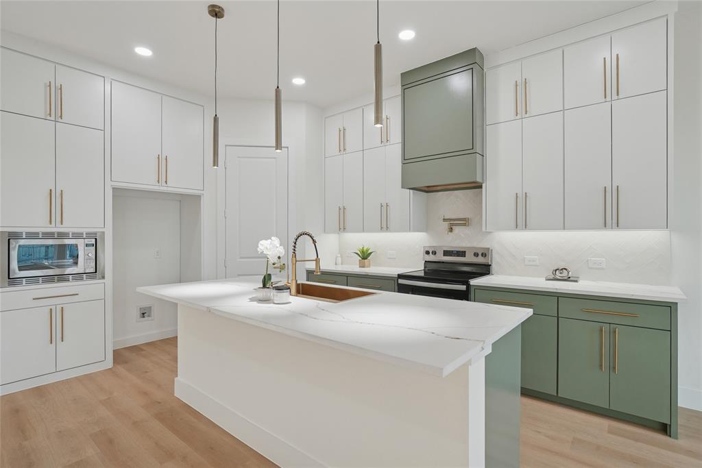 1147 Riverwood Road Dallas, TX 75217 - Photo 4 of 26 a kitchen with a sink a stove and cabinets