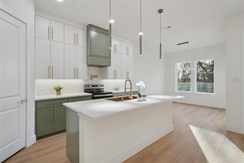 1147 Riverwood Road Dallas, TX 75217 - Photo 5 of 26 a kitchen with stainless steel appliances granite countertop a sink a stove a refrigerator and white cabinets with wooden floor