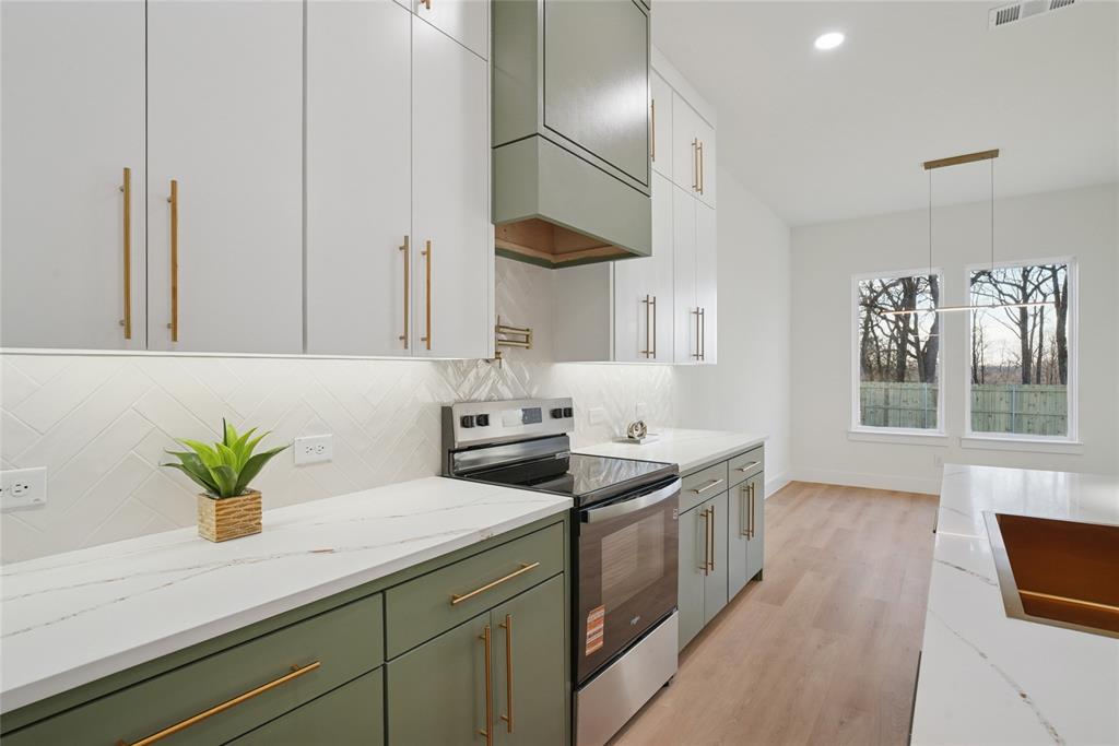 1147 Riverwood Road Dallas, TX 75217 - Photo 6 of 26 a kitchen with stainless steel appliances granite countertop a sink a stove and a window