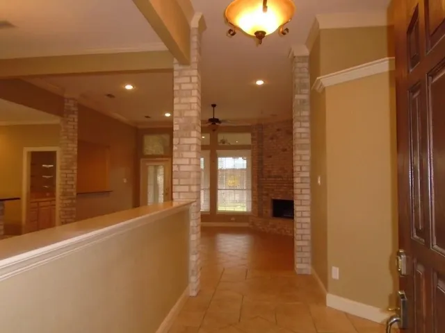a view of a hallway with wooden floor and a kitchen