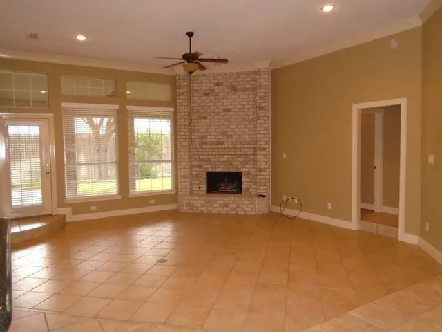 a view of an empty room with a fireplace and a window