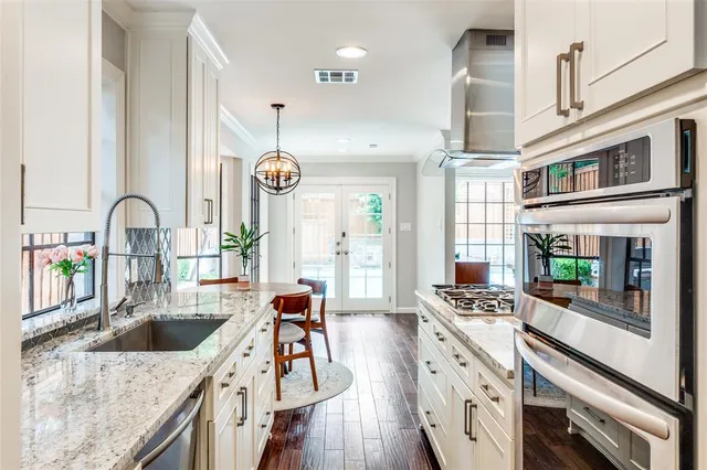 a kitchen with stainless steel appliances granite countertop a sink stove and cabinets
