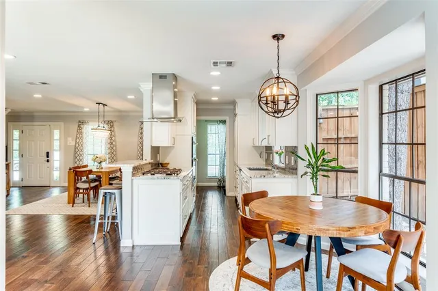 a dining room with furniture a chandelier and wooden floor