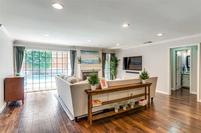 a living room with furniture a wooden floor and a large window