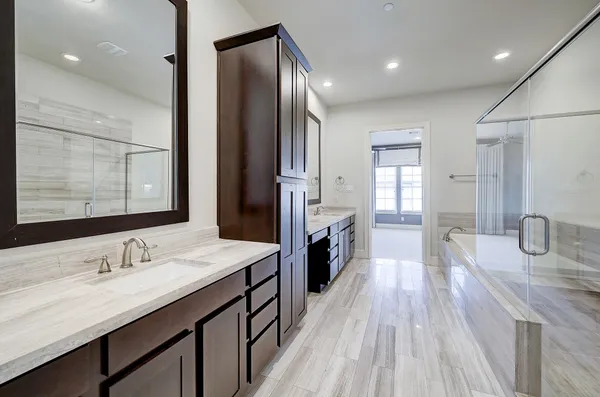 a spacious bathroom with a granite countertop sink a toilet a mirror and shower
