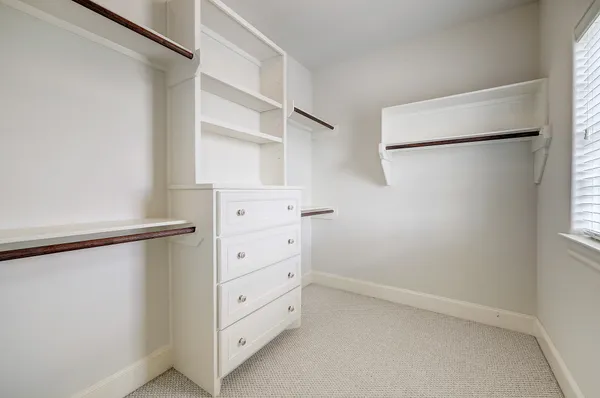 a view of walk in closet with empty racks