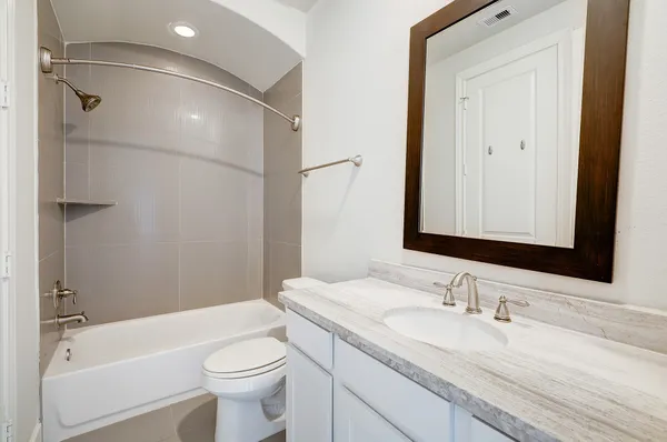 a bathroom with a granite countertop sink toilet and shower