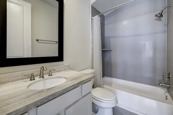 a bathroom with a granite countertop sink toilet and shower