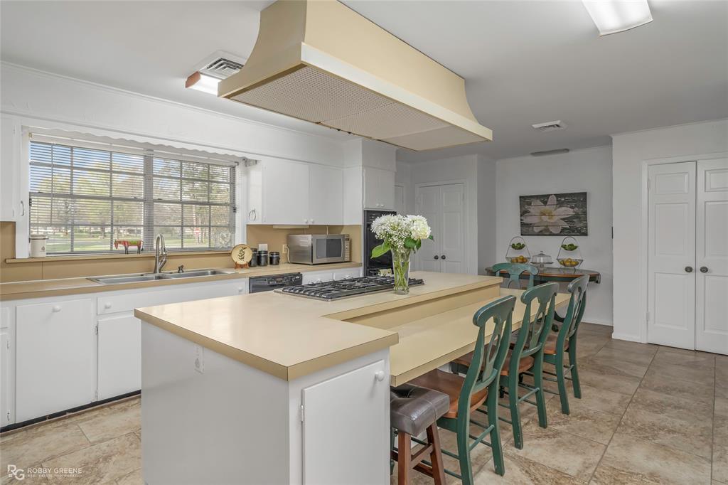 701 Palmetto Road Benton, LA 71006 - Photo 9 of 28 a kitchen with a table chairs and a refrigerator