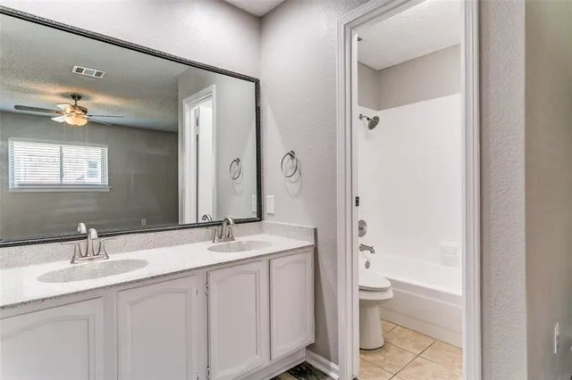 a bathroom with a granite countertop sink a toilet and a mirror