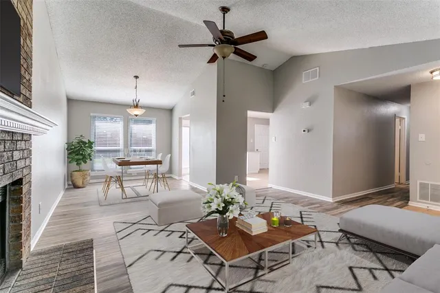 a living room with furniture a fireplace and a chandelier