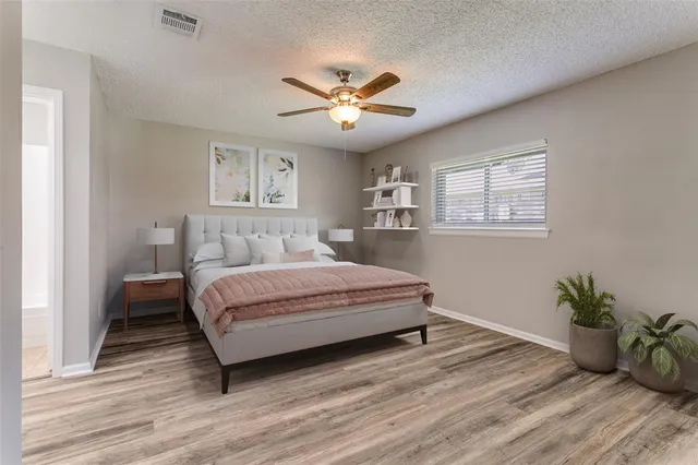 a bedroom with a large bed and a chandelier