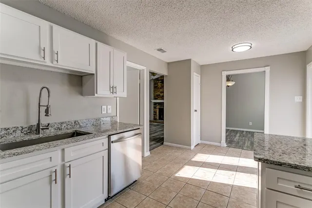 a kitchen with granite countertop a sink and cabinets