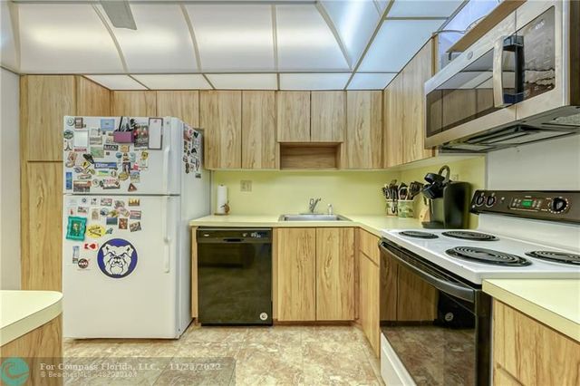 a kitchen with a refrigerator and a stove top oven