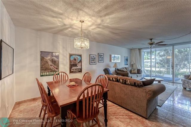 a living room with furniture a chandelier and a dining table