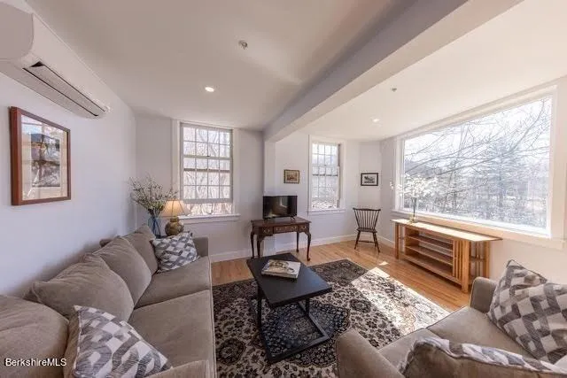a living room with furniture wooden floor and a window