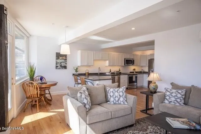 a living room with furniture and view of kitchen