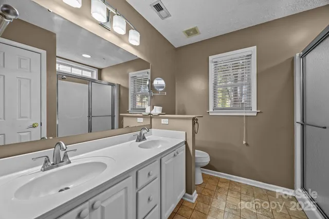 a bathroom with a sink double vanity and a toilet