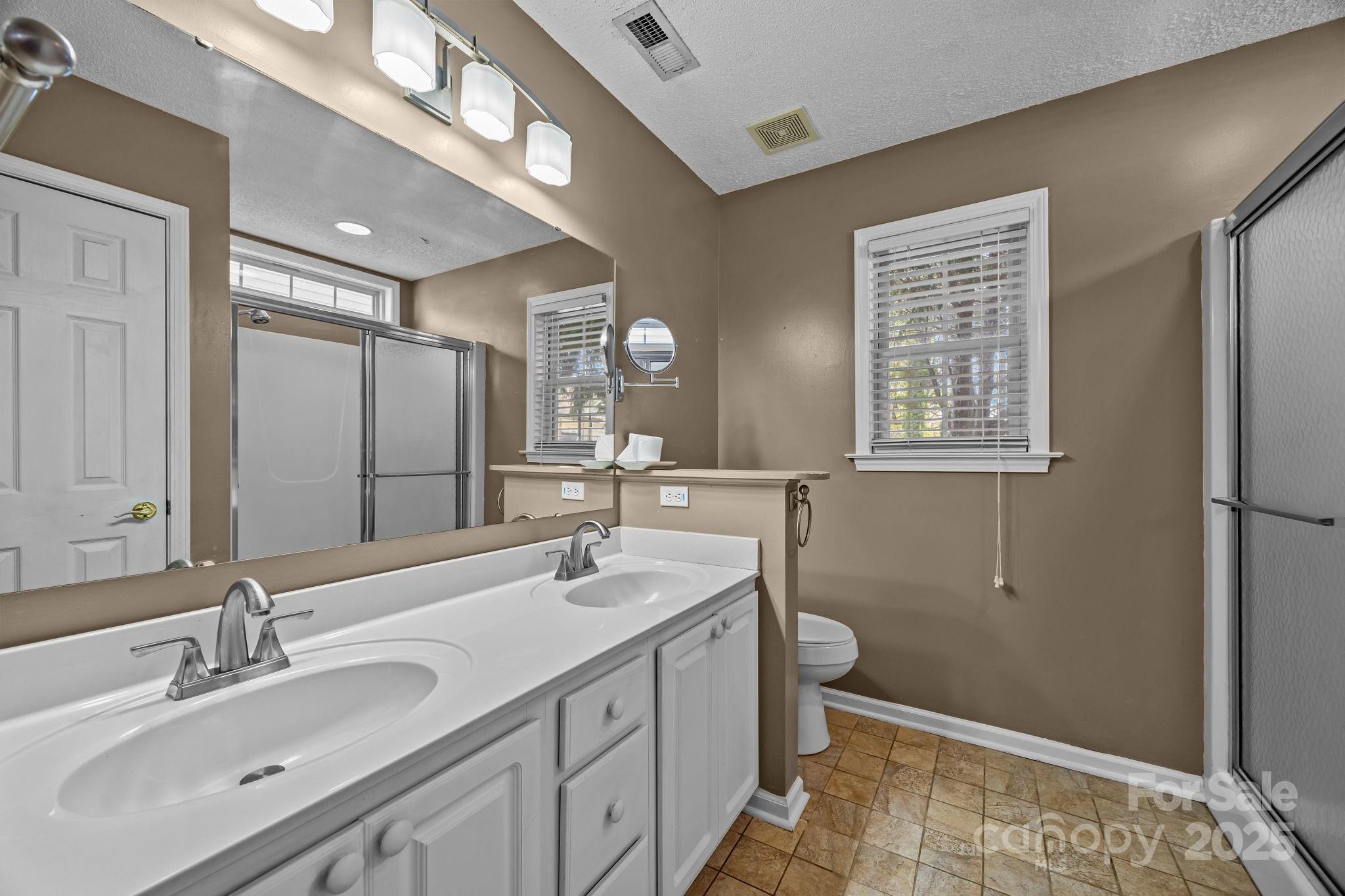 255 Stonehollow Road Fletcher, NC 28732 - Photo 17 of 32 a bathroom with a sink double vanity and a toilet