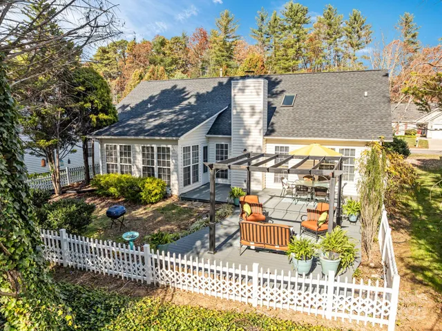 a view of a house with a small yard and wooden fence