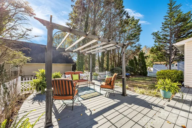 a view of a patio with a dining table and chairs with wooden floor and fence