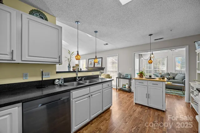 a kitchen with stainless steel appliances granite countertop a sink stove and wooden cabinets
