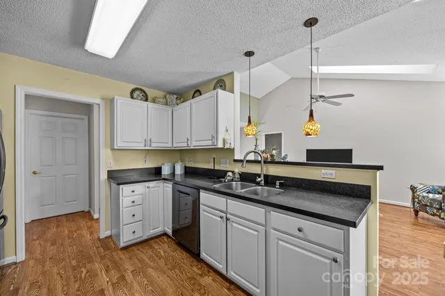 a kitchen with granite countertop a sink cabinets and stainless steel appliances