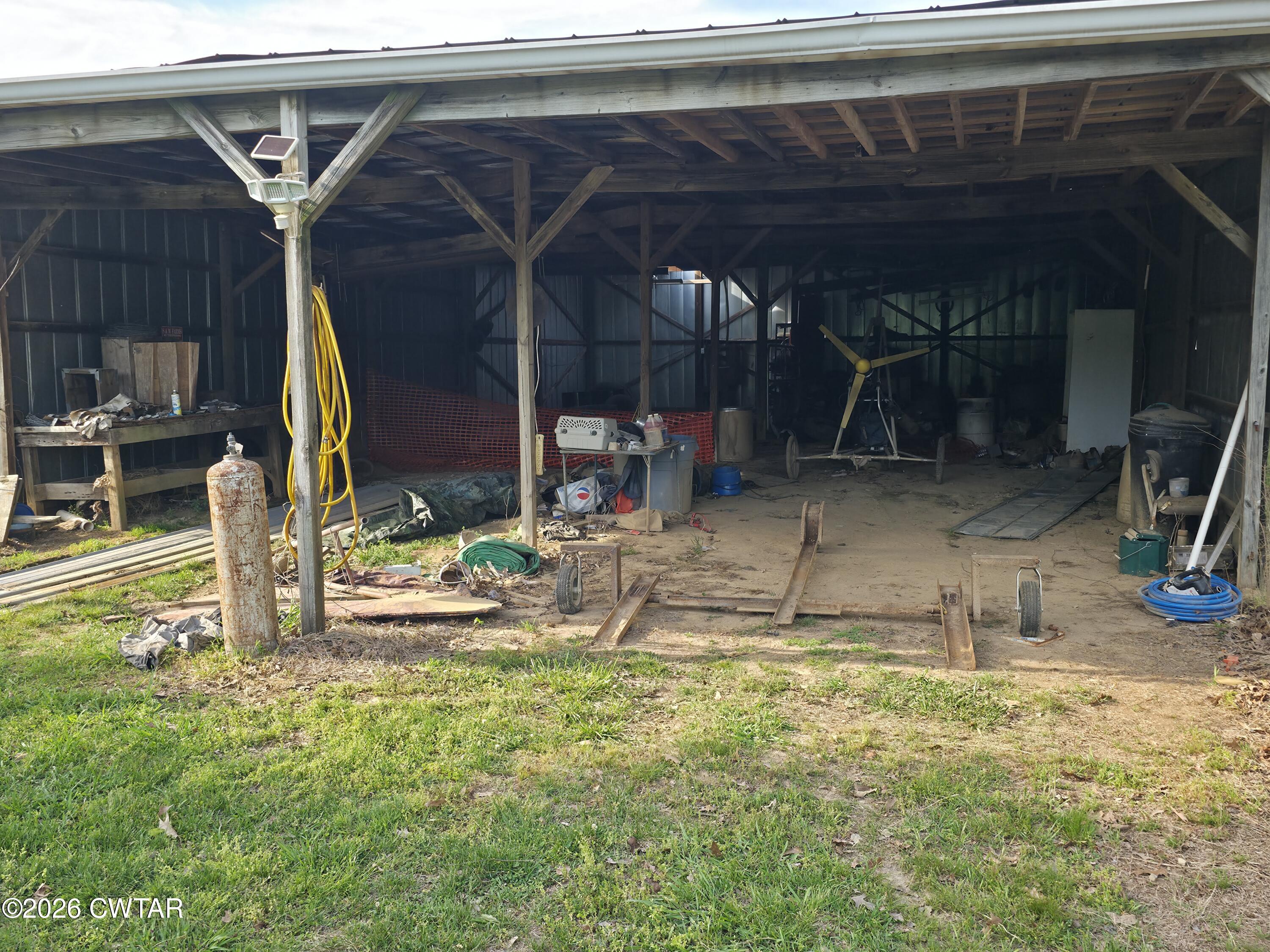 111 Leighton County Line Road Denmark, TN 38391 - Photo 17 of 53 a view of a backyard with a wooden roof and a table and chairs