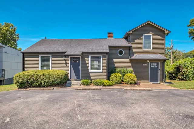 a front view of a house with a yard and outdoor seating