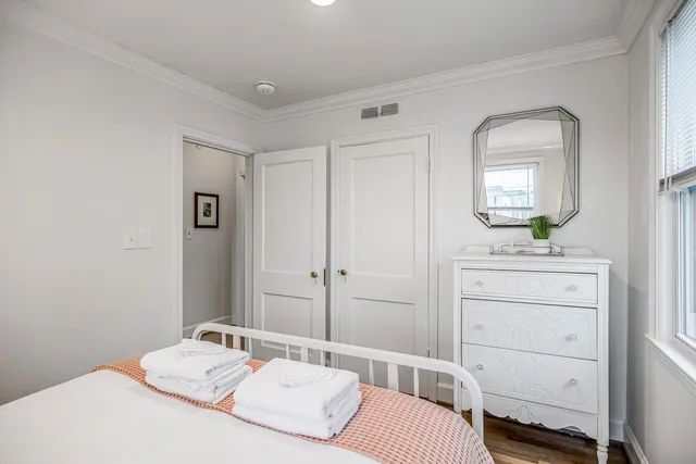 a bedroom with a bed and a lamp next to a window