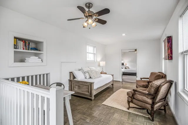 a sink with granite countertop white cabinets and a wooden floor