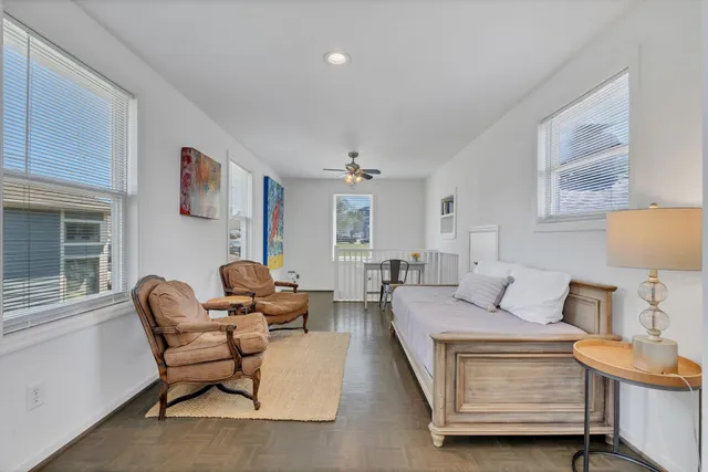 a view of a roof deck with table and chairs a barbeque with wooden floor and fence