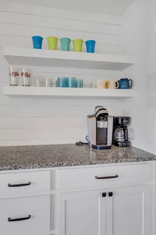 a front view of a house with a yard and potted plants