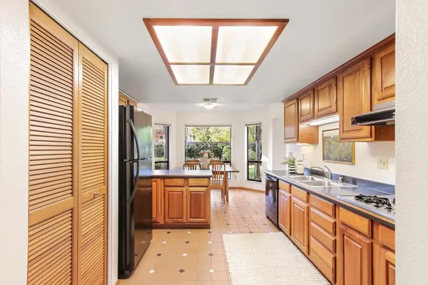 a large kitchen with stainless steel appliances granite countertop a stove a sink and a refrigerator