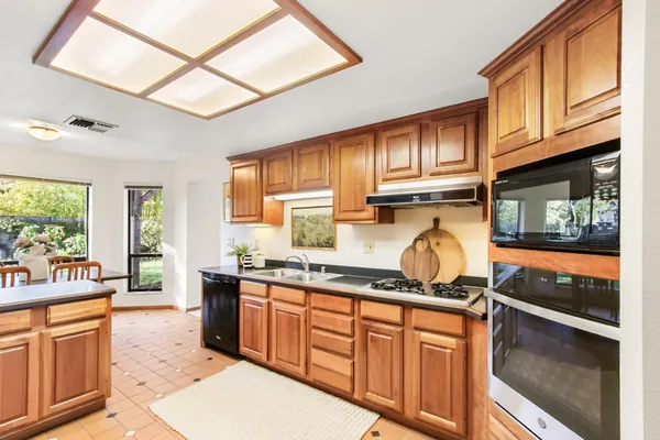 a kitchen with granite countertop a stove sink cabinets and refrigerator