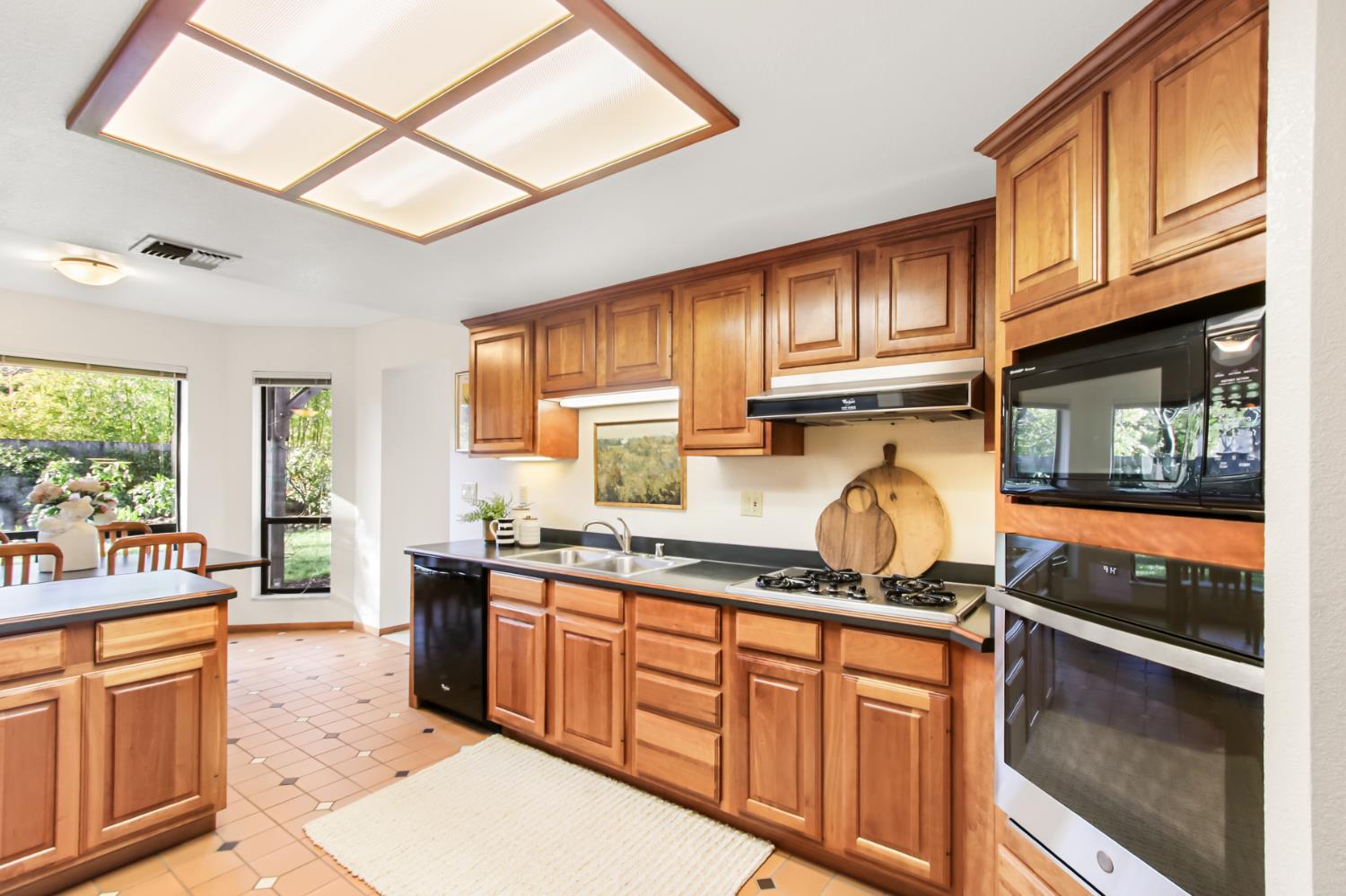 2216 Bryce Lane Davis, CA 95616 - Photo 14 of 53 a kitchen with granite countertop a stove sink cabinets and refrigerator