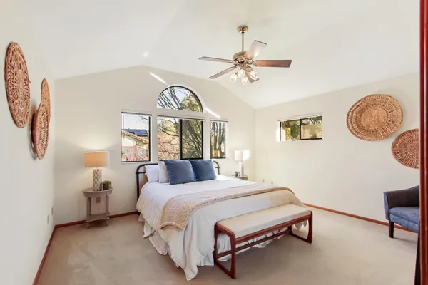 a bedroom with a bed a chandelier and a window