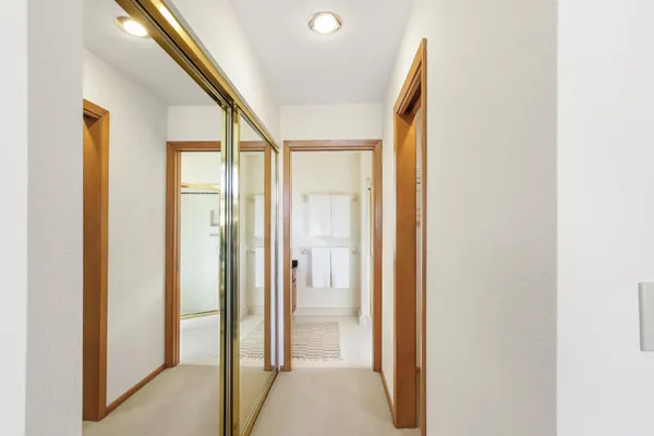 a view of a hallway with wooden floor and glass doors