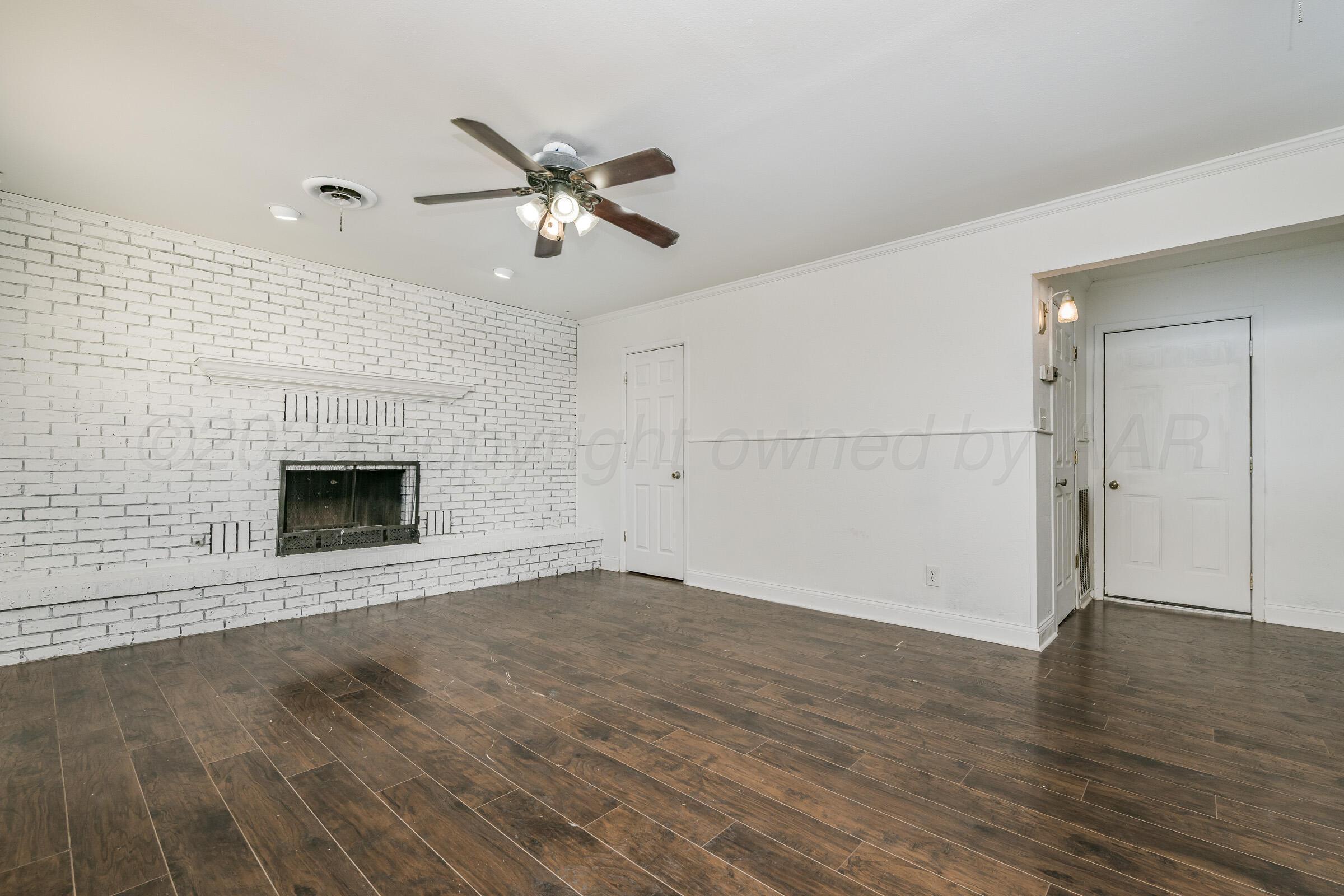 4929 Southwest 16th Avenue Amarillo, TX 79106 - Photo 13 of 19 an empty room with wooden floor a ceiling fan and windows