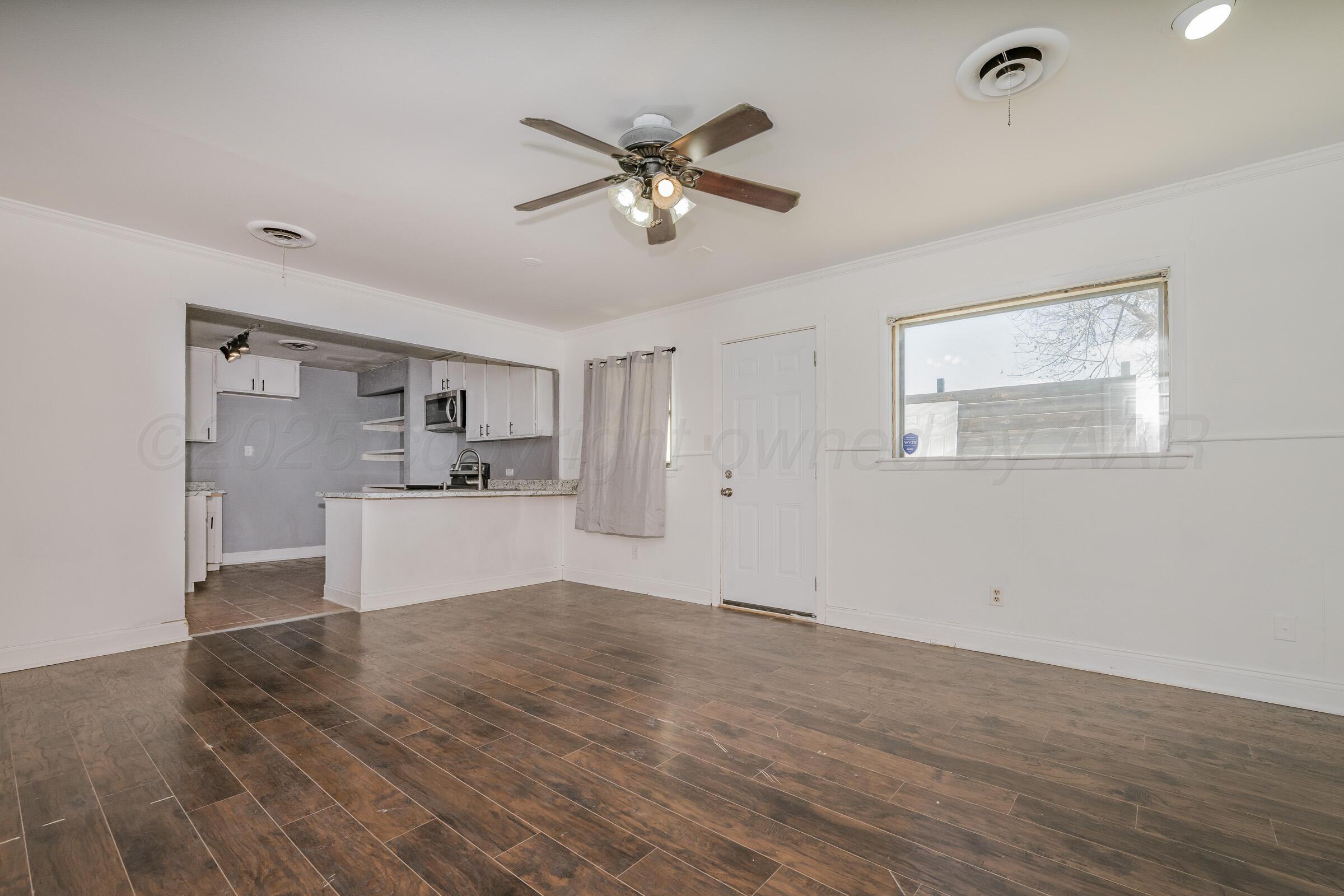 4929 Southwest 16th Avenue Amarillo, TX 79106 - Photo 14 of 19 a view of a livingroom with a ceiling fan wooden floor and a ceiling fan