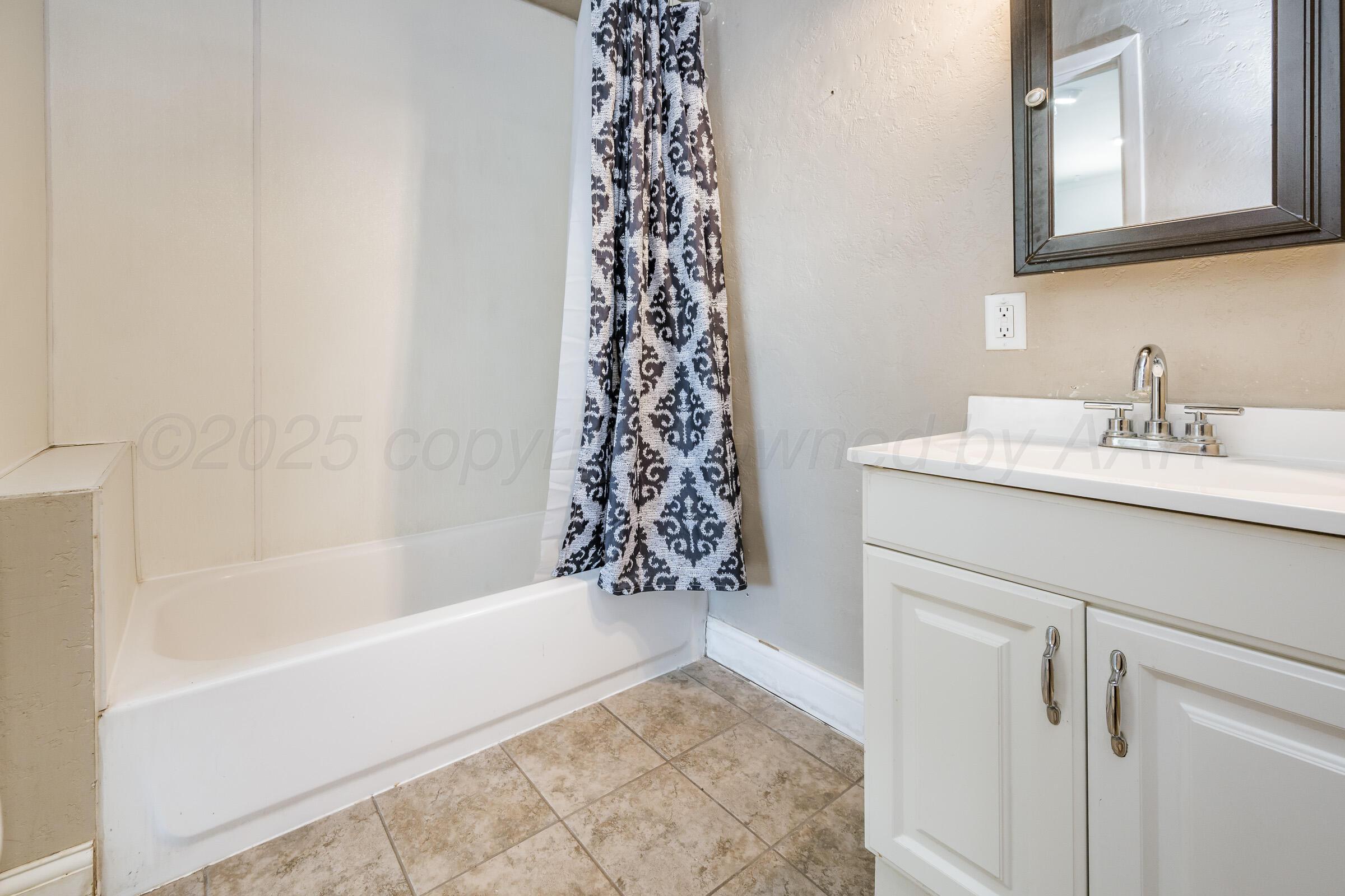 4929 Southwest 16th Avenue Amarillo, TX 79106 - Photo 15 of 19 a bathroom with a bathtub a sink and a shower