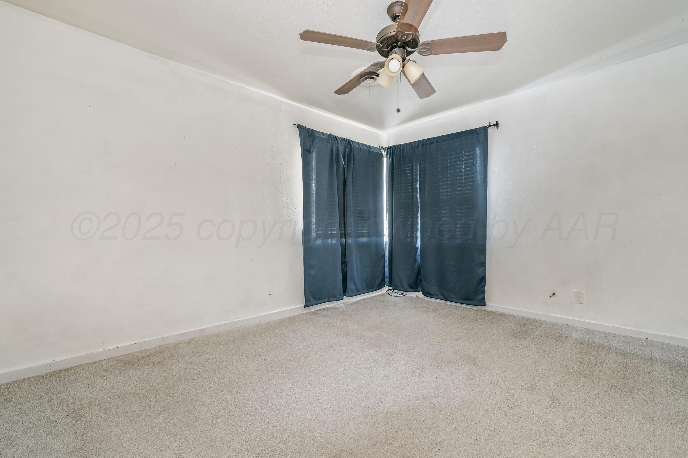 4929 Southwest 16th Avenue Amarillo, TX 79106 - Photo 17 of 19 an empty room with a fan & a ceiling fan