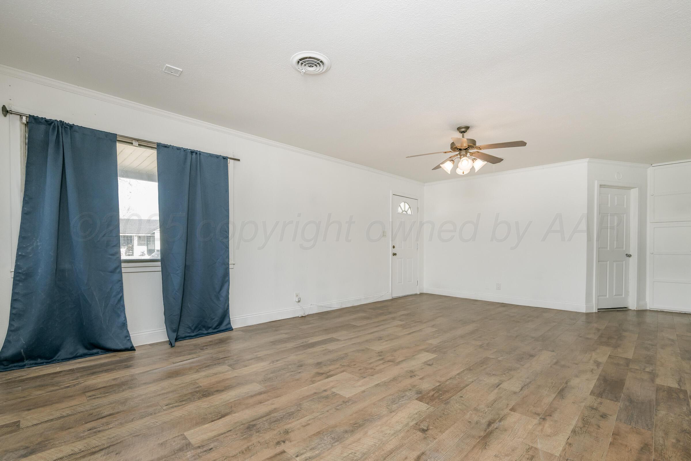 4929 Southwest 16th Avenue Amarillo, TX 79106 - Photo 7 of 19 a view of an empty room with wooden floor and a window