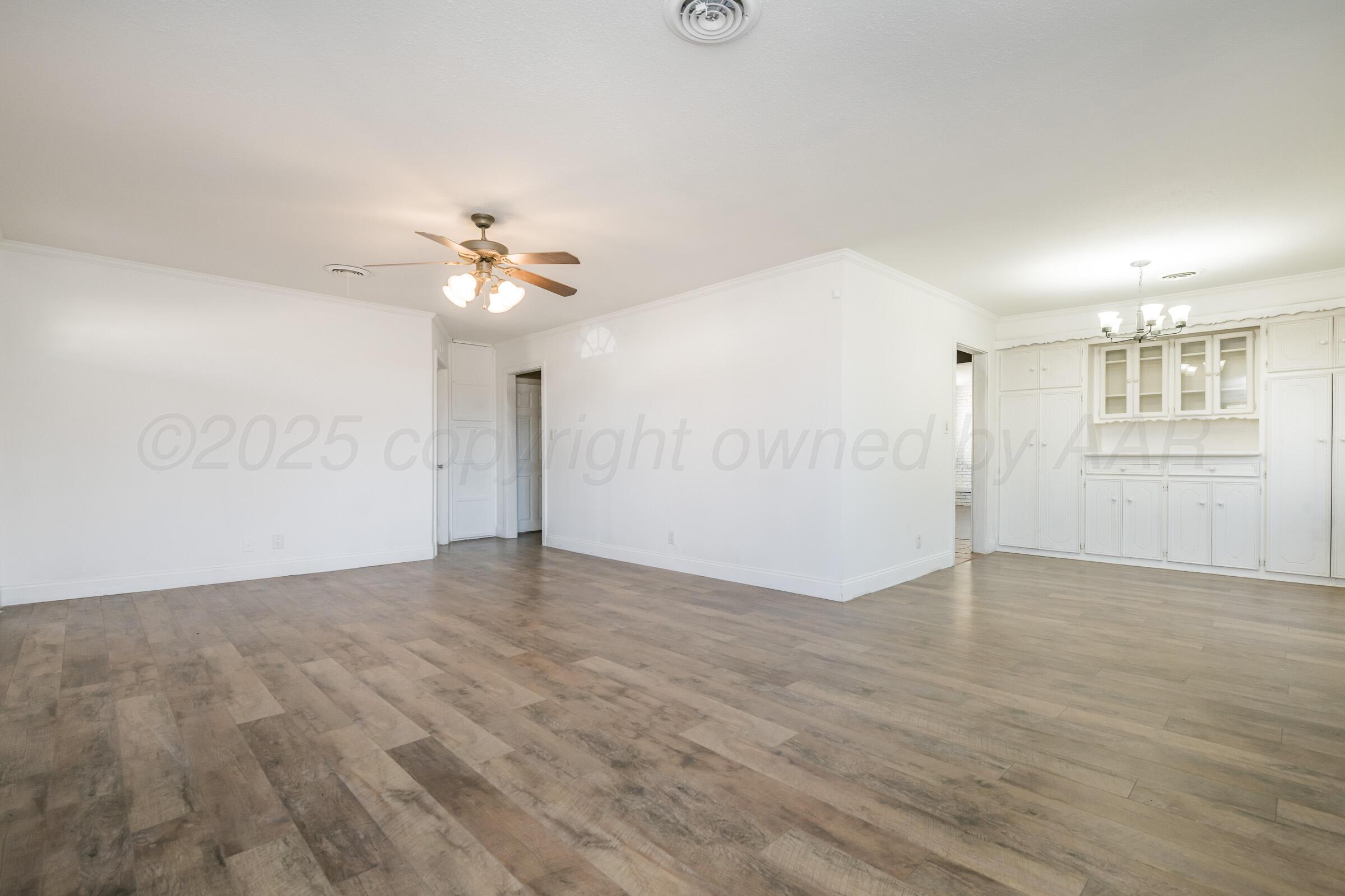 4929 Southwest 16th Avenue Amarillo, TX 79106 - Photo 9 of 19 wooden floor in an empty room with a chandelier fan