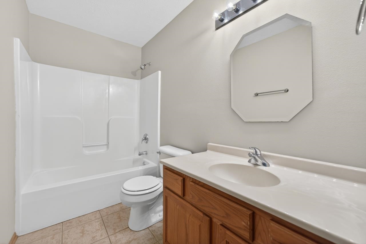 676 Elberon Way Roscoe, IL 61073 - Photo 29 of 30 a bathroom with a granite countertop sink a toilet and a bathtub