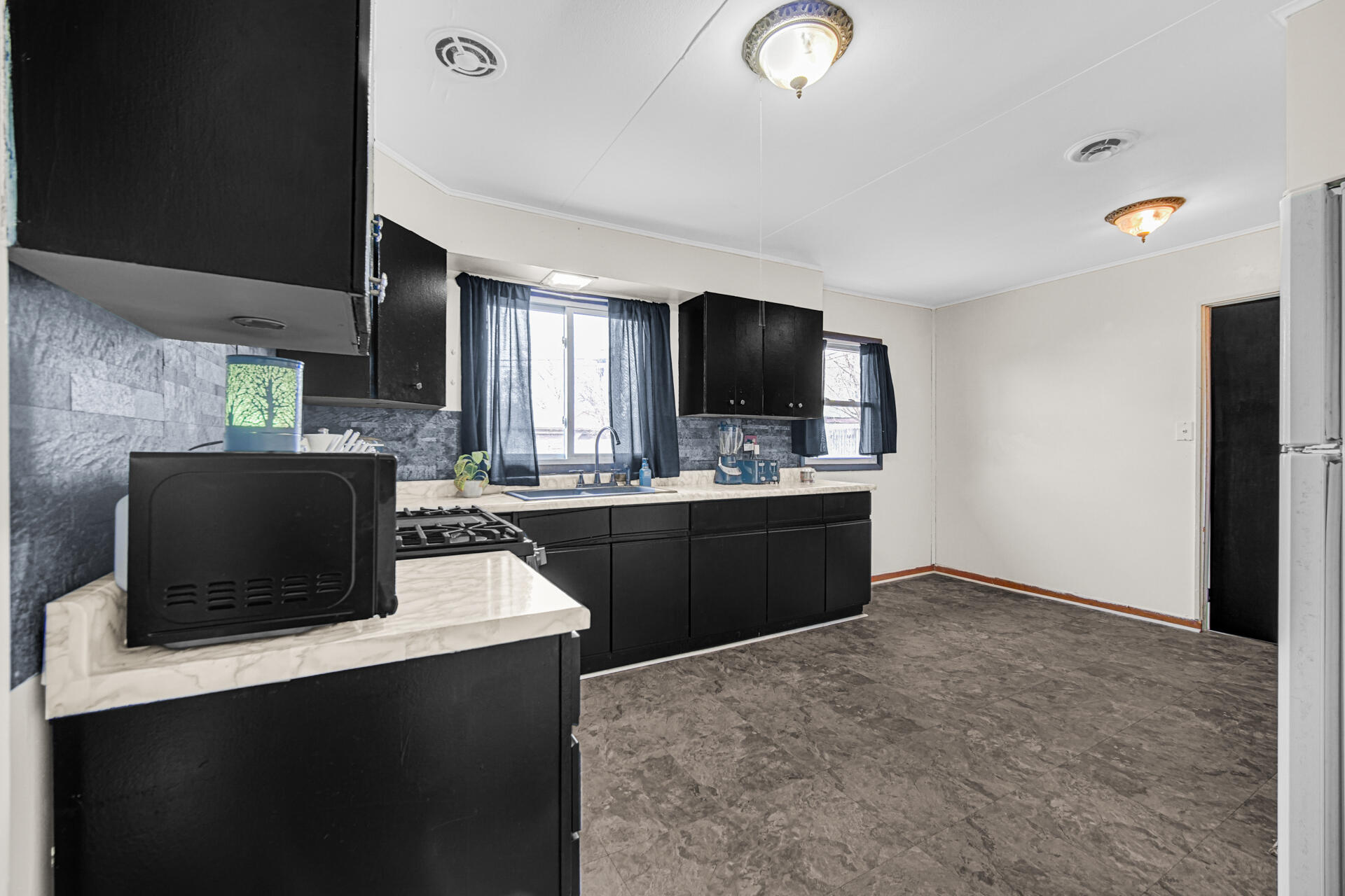 1639 174th Street Hammond, IN 46324 - Photo 2 of 21 a kitchen with a refrigerator and a television