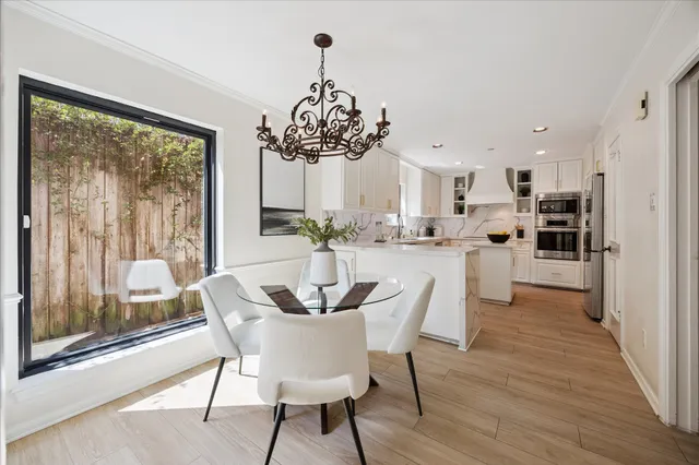 a dining room with furniture a chandelier and wooden floor